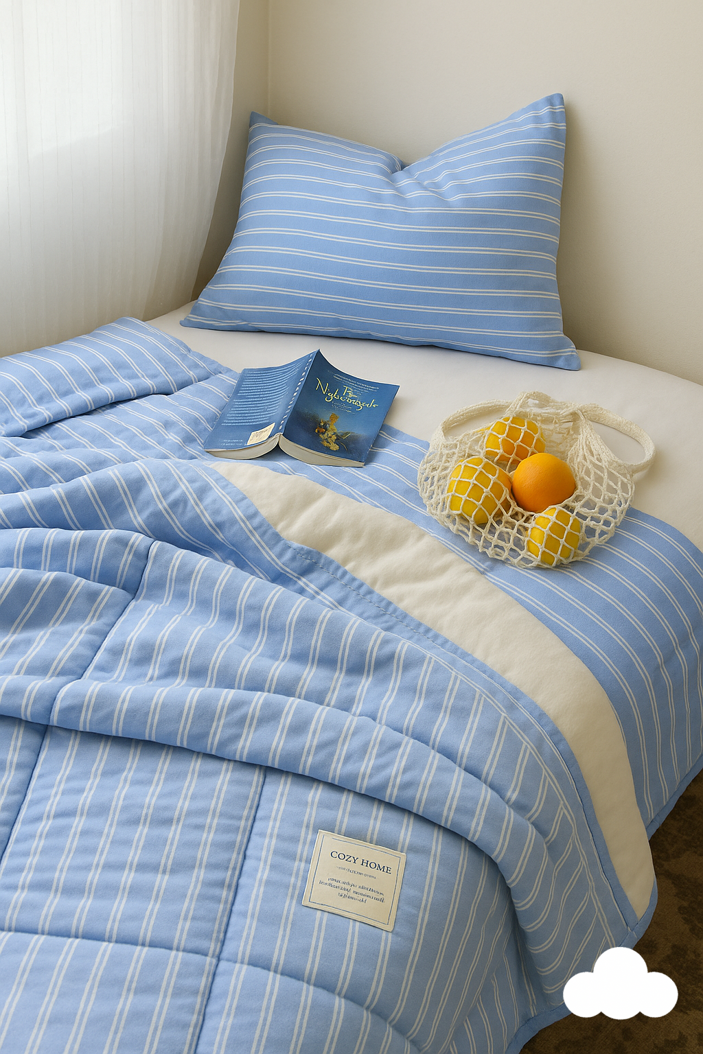 A cozy sunlit bedroom with soft blue and white striped bedding, a book open on the bed, and a mesh bag filled with oranges and lemons — showcasing a peaceful, layered textile aesthetic perfect for cozy home styling.